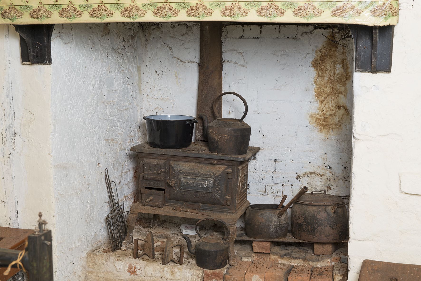 An old metters stove at Mugga Mugga Cottage kitchen sits in an acolve with white washed brick walls.